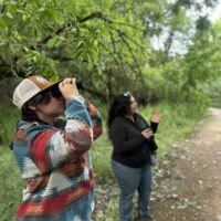 Restorationist looking at birds on a guided walk