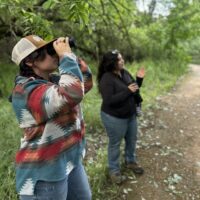 Restorationist looking at birds on a guided walk
