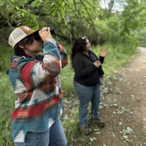 Restorationist looking at birds on a guided walk
