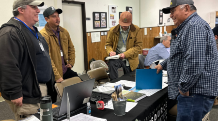 ESRCD Staff, Chris Yohanan, and Gonzo Garcia assisting a local farmer at a technical assistance fair.