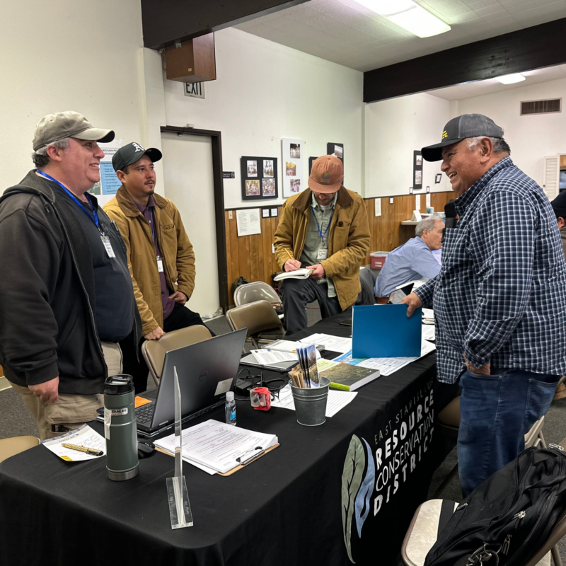 ESRCD Staff, Chris Yohanan, and Gonzo Garcia assisting a local farmer at a technical assistance fair.